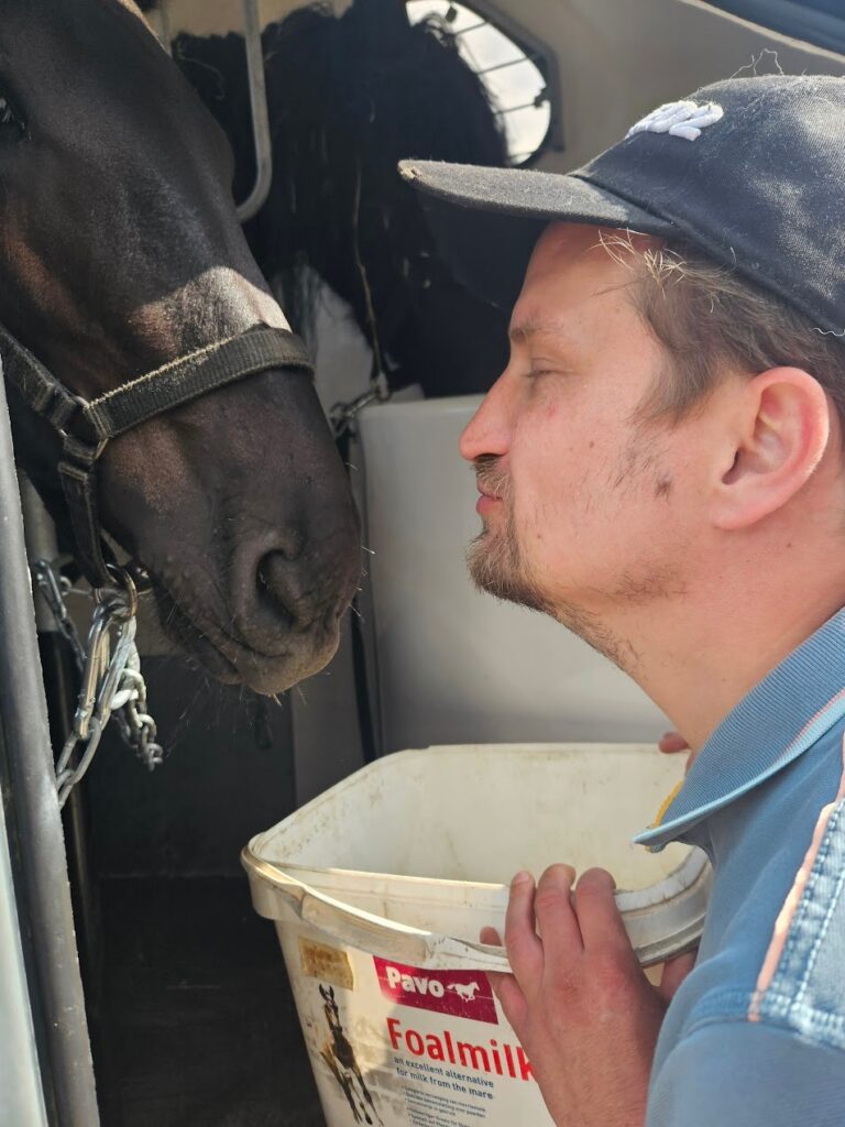 Man met paard die een kussende beweging maakt bij zorgboerderij Annabelle, dagbesteding.